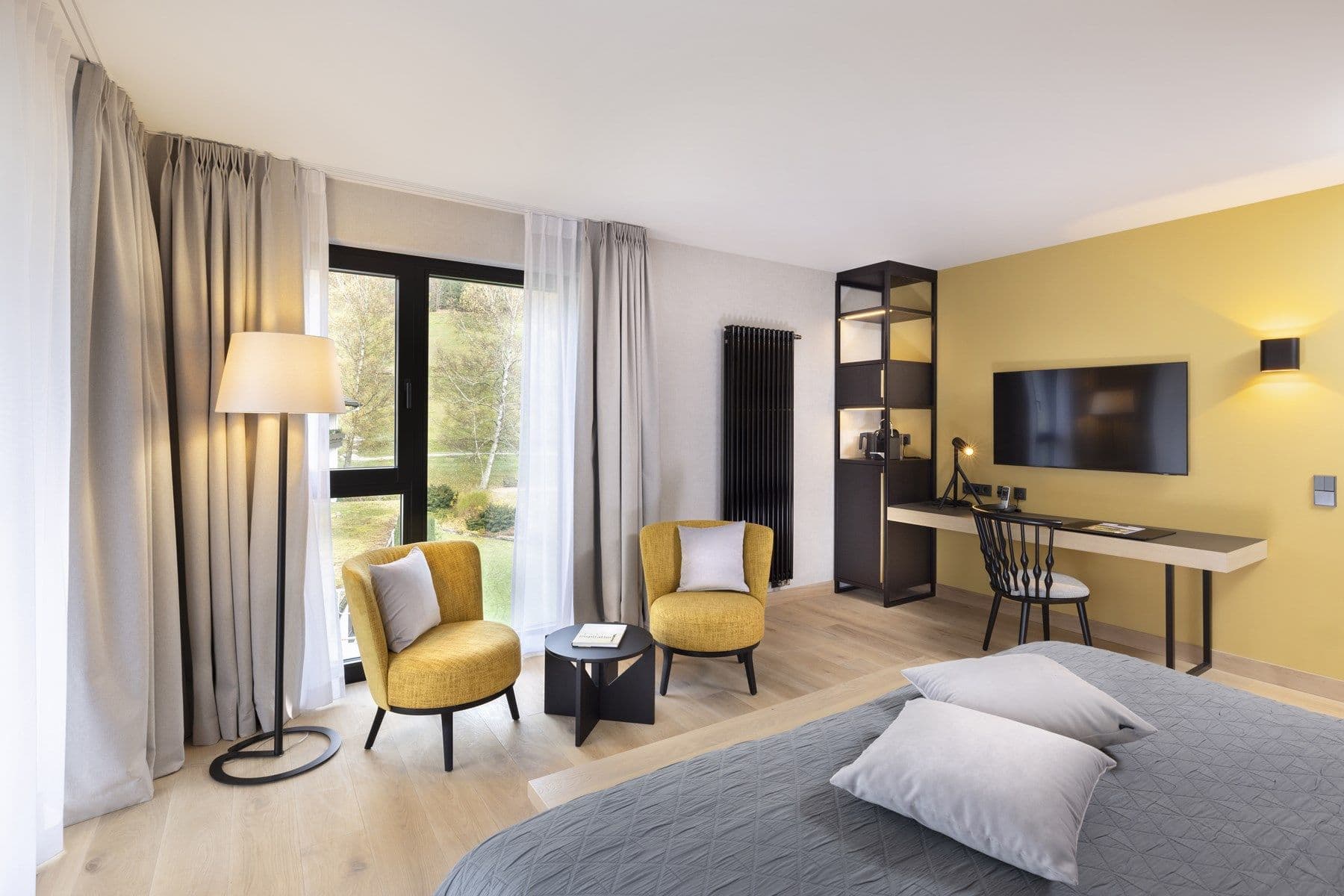 Modernes Superior Doppelzimmer – Sitzecke mit gelben Sesseln und Balkontür