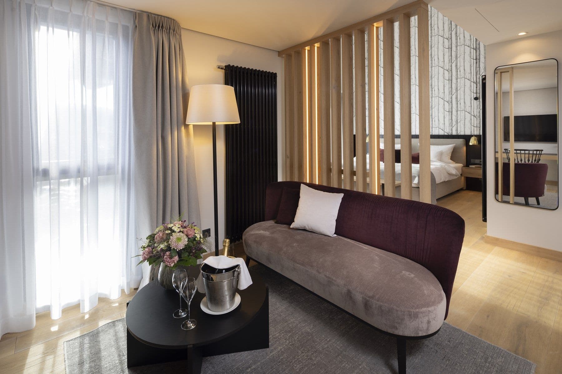 Modernes Superior Juniorsuite – Wohnbereich mit Sofa und Lamellen-Trennwand