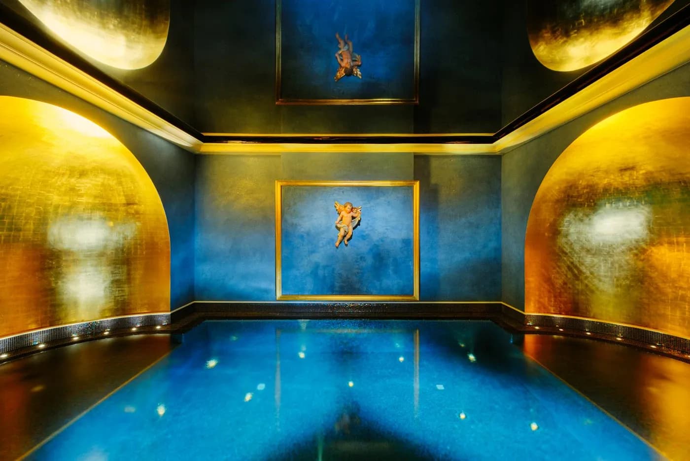 Schwebebad auf Wolke 7 im Engel Obertal – tiefblauer Floating-Pool zwischen goldenen Wandbögen, an der Wand ein Engelsrelief im Goldrahmen