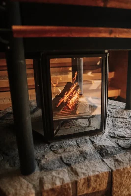Detailaufnahme eines Kaminfeuers hinter Glas auf einem Steinsockel